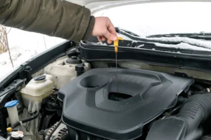 side view of mechanic checking car oil level